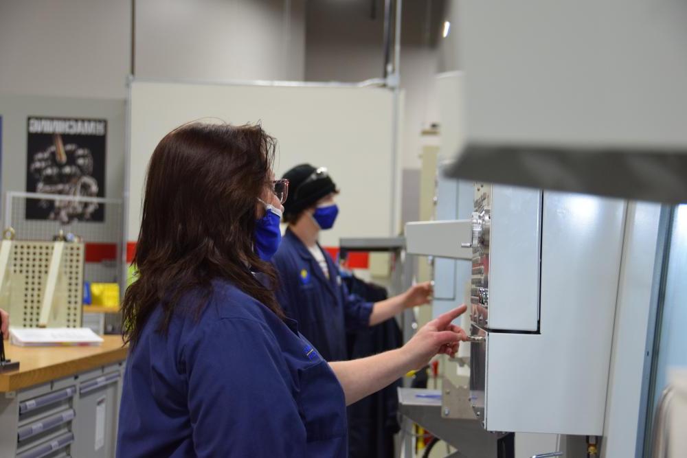 A technology student pushing buttons on a machine